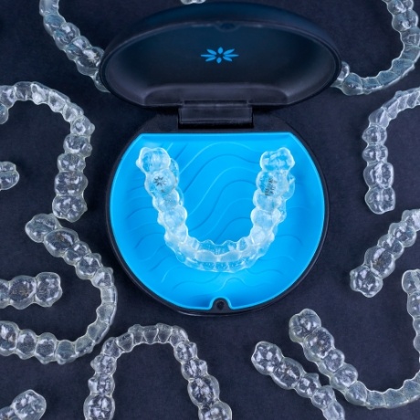Table with several Invisalign clear aligners in Corinth