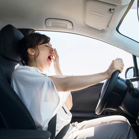 Woman falling asleep behind the wheel of a car