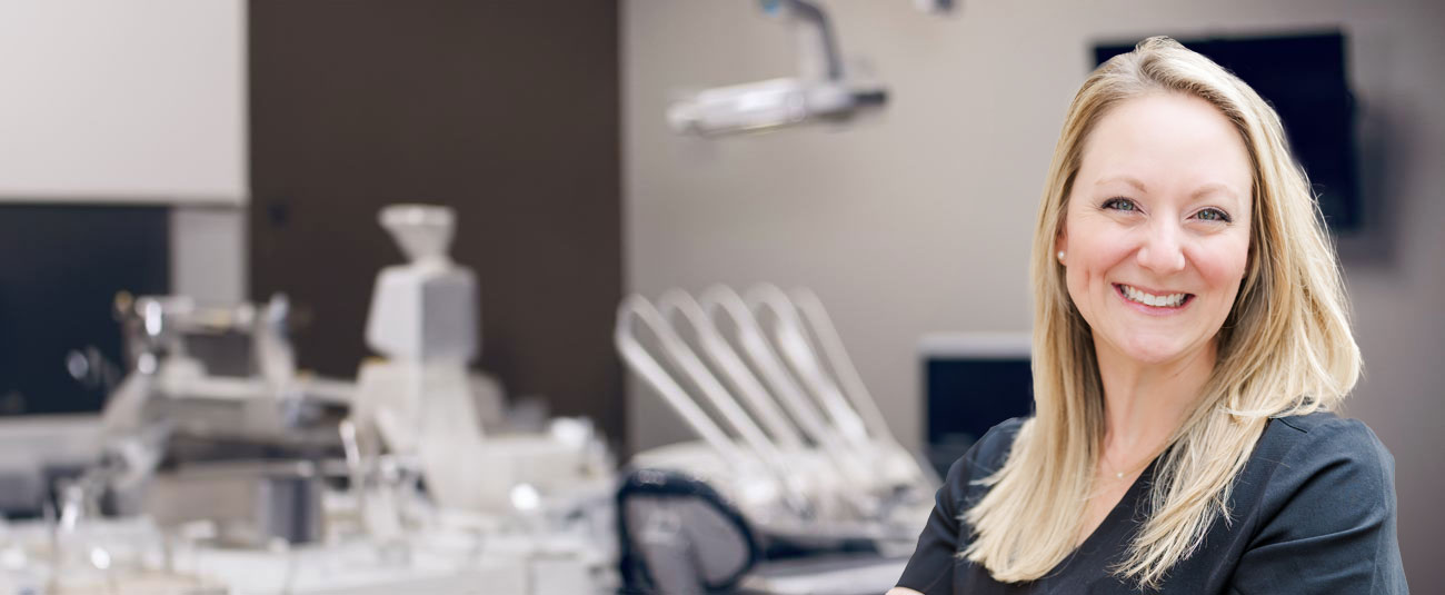 Corinth dentist Doctor Kristina Mackie smiling in white lab coat